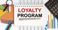 Notebook with Tools and Notes with text Loyalty Program on the charts