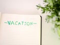 Notebook with VACATION written, holiday concept