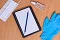 Notebook with vacuum tubes for blood collection and rubber gloves on a wooden table Royalty Free Stock Photo