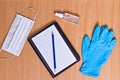 Notebook with vacuum tubes for blood collection and rubber gloves on a wooden table Royalty Free Stock Photo