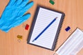 Notebook with vacuum tubes for blood collection and rubber gloves on a wooden table Royalty Free Stock Photo