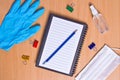 Notebook with vacuum tubes for blood collection and rubber gloves on a wooden table Royalty Free Stock Photo