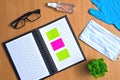 Notebook with vacuum tubes for blood collection and rubber gloves on a wooden table Royalty Free Stock Photo