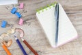 The notebook on which there is a pen of silver and next to pencil sharpening shavings and a few pencils on a wooden table Royalty Free Stock Photo