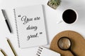 Notebook with wisdom quote and coffee cup. Royalty Free Stock Photo