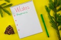 Notebook with wishes for Santa Claus on a yellow Christmas background with a bell of spruce nuts Royalty Free Stock Photo