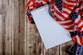 Notebook on wood table beautifully waving star and striped American flag for background Royalty Free Stock Photo