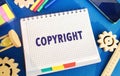 Notebook with the word Copyright. Patenting. Copyright protection. Brand and patent. The fight against online piracy. Gears,