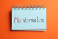 Notebook with word MISINFORMATION on orange background, top view Royalty Free Stock Photo