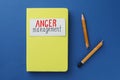 Notebook with words Anger Management and broken pencil on blue background, flat lay Royalty Free Stock Photo