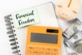 Notebook with words Financial Freedom, piggy bank, dollars and calculator on white table, flat lay Royalty Free Stock Photo