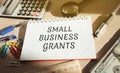Notebook with words Small Business Grants. Free money for startups and existing businesses, including those impacted by the