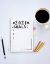 Notebook for writing New Year's resolutions on a table with a coffee cup on the side with colored pencils on the sides Royalty Free Stock Photo
