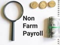 Notebook written NON FARM PAYROLL with coins,fake money and magnifying glass. Royalty Free Stock Photo