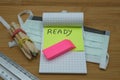 A notebook with written ready,a pink eraser some colored pencils, a ruler and a mask for the face Royalty Free Stock Photo