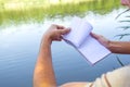 Notebook of a young man, a man close to the lake, painting landscape in Notepad. Summer Sunny day. to turn the page Royalty Free Stock Photo