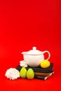 Notebooks, Easter eggs and white tea pot on a red background Royalty Free Stock Photo