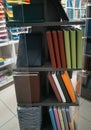 Notebooks and diaries on shelf of art shop. Notepads and diaries of different colors.