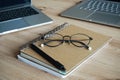 Notebooks, glasses and two open laptops next to each other on a wooden table Royalty Free Stock Photo