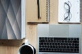 Notebooks with a pen, glasses, folders, an open laptop, a cup of coffee next to it on a wooden table Royalty Free Stock Photo