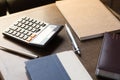 Notebooks, pens and calculator on table