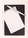 Notepad, black notebook and a silver pen Royalty Free Stock Photo