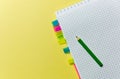 Notepad with bookmarks, pencil for recording on yellow background. Office theme.