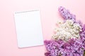 Notepad and branches of beautiful white and purple lilacs on pink background. Top view. Copy space. Mockup Royalty Free Stock Photo
