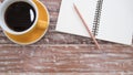 Notepad and coffee cup on wood table