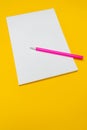 Notepad with copy space with pink pen on yellow background.Simple bright background with place for text Royalty Free Stock Photo