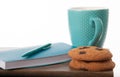 Notepad, cup, pen in turquoise color with chocolate chip cookies. wooden table and white background. Great morning and start of th Royalty Free Stock Photo