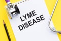 A notepad with the diagnosis Lyme Disease, a stethoscope and a black pencil on yellow surface