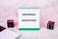 Notepad displaying universal education concept alongside dice and calculator symbolizes the intersection of education