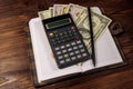 Notepad with dollars, pencil and calculator on wooden desk. Financial planning concept Royalty Free Stock Photo