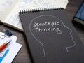 Notepad with drawn head and sign strategic thinking. Royalty Free Stock Photo