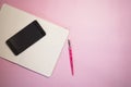 Notepad with empty place for text and phone on a pink background Royalty Free Stock Photo