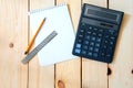 Notepad for entries with a calculator. pencil and ruler on a wooden table.