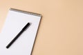 Notepad with erasable pen on beige background, top view. Space for text