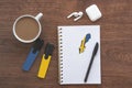 notepad with flag of sweden, wireless headphones, coffee cup, pen, markers on brown table,