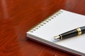 notepad with fountain pen on polished cherry desk Royalty Free Stock Photo