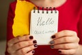 Notepad hello autumn and Yellow autumn leaf in female hands in a Royalty Free Stock Photo