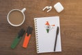 notepad with india flag, wireless headphones, coffee cup, pen, markers on brown table,