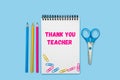 Notepad with inscription Thank you Teacher on the blue background. Teacher\'s Day. Flatlay. Top view Royalty Free Stock Photo