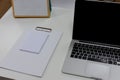 Notepad and laptop on white wooden desk. View from above with copy space in white tone. Work environment and office background Royalty Free Stock Photo