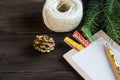 Notepad lays on the wooden background to make a list to do things or list of presents for friends and family. New year