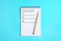 Notepad with list of rules and pencil on blue background, top view Royalty Free Stock Photo