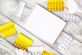 Notepad with medical supplies and pills on white wooden background. Cold, virus flu cure medical concept Royalty Free Stock Photo