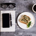 Notepad, mobile phone, pen, succulent, glasses, cup of coffee on a gray cement background. Royalty Free Stock Photo