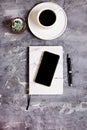 Notepad, mobile phone, pen, succulent, glasses, cup of coffee on a gray cement background. Royalty Free Stock Photo