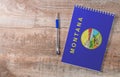 Notepad with Montana flag, pen on wooden background